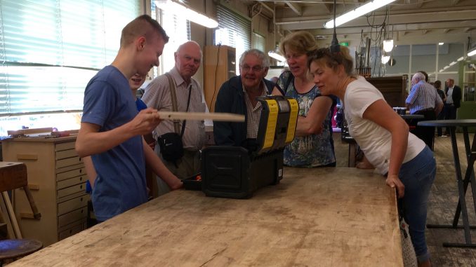 Een jonge medewerker van Flentrop geeft belangstellenden een toelichting bij zijn vak.